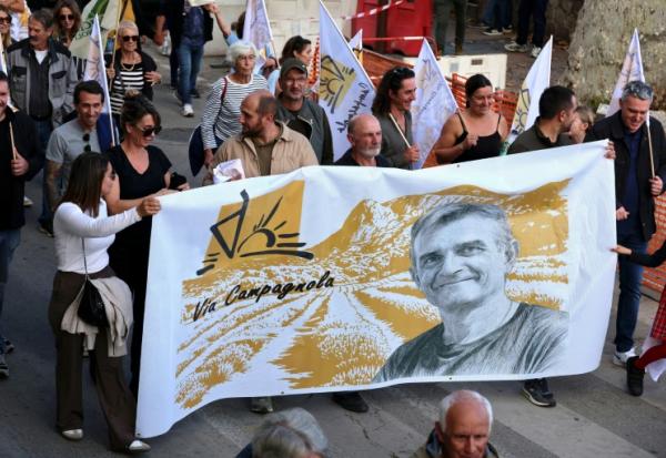 A Ajaccio, des manifestants tiennent une banderole à l'effigie de Pierre Alessandri le 15 novembre 2025
