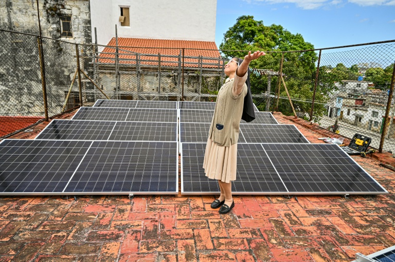 Soeur Gertrudis Abreu, une religieuse dominicaine vivant à Cuba, remercie Dieu devant un système de panneaux solaires flambat neuf installé sur le toit d'une cantine pour indigents géré par l'Eglise catholique, dans le quartier de Guanabacoa, à La Havane le 4 février 2026