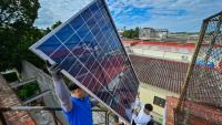 Une équipe de techniciens de systèmes photovoltaïques hisse des panneaux sur le toit d'une cantine pour personnes âgées géré par l’Eglise catholique, dans le quartier de Guanabacoa à La Havane, le 4 février 2026