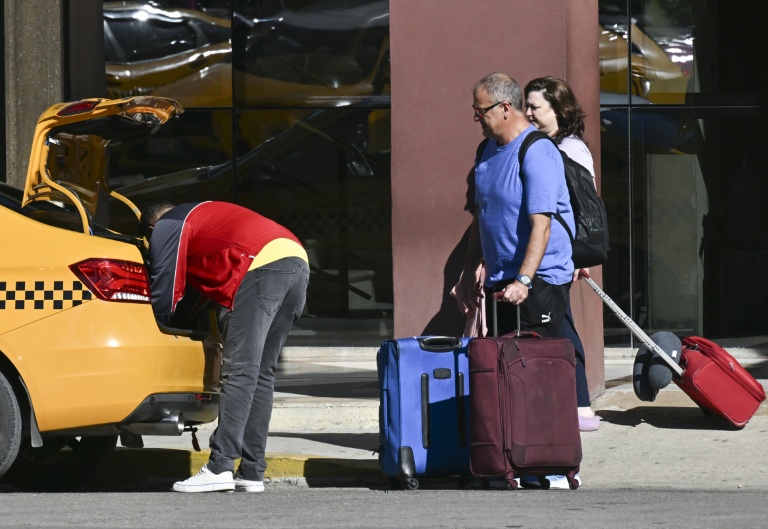 Des touristes prennent un taxi dans une rue de La Havane, le 11 février 2026 à Cuba
