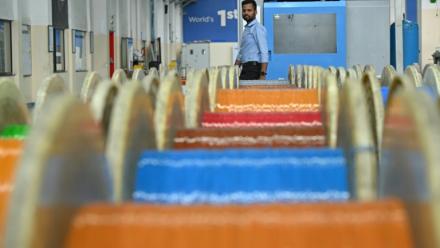 Un employé passe devant des câbles de fibre optique dans l'usine de Sterlite Technologies Limited (STL) à Chhatrapati Sambhaji Nagar, dans l'Etat de Maharashtra, en Inde, le 9 juillet 2026