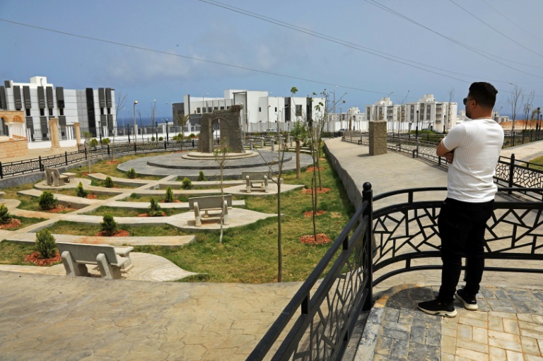 Un homme observe le nouveau projet de logements en construction dans le quartier d'Al-Salam à Derna, le 17 mai 2026, dans le cadre du plan de reconstruction de la ville, près de trois ans après le passage dévastateur d'une tempête qui a fait près de 4 000 victimes
