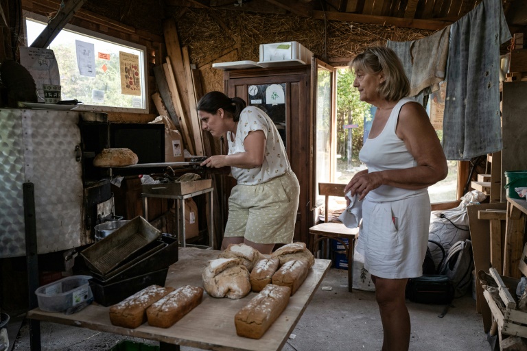 Des femmes font cuire du pain dans un four du