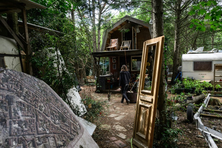 Une femme devant une cabane du