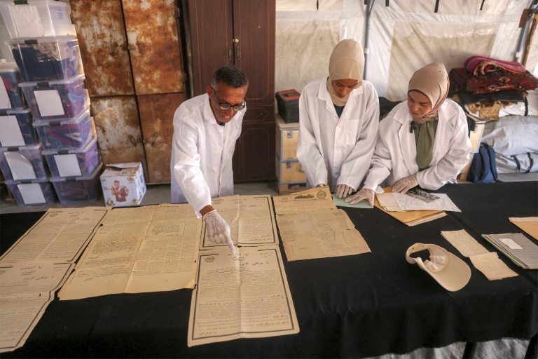 Des membres de l'association Mayasem pour la culture et les arts, examinent des documents anciens, le 11 juillet 2026 à Khan Younès, dans le sud de la bande de Gaza