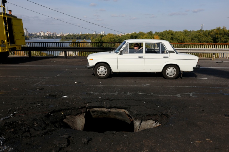 Une voiture passe sur un pont à Kiev, endommagé par une frappe de drone russe, le 4 octobre 2026