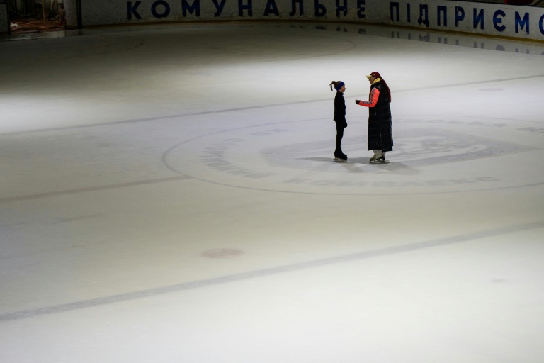 Une entraîneuse ukrainienne échange avec une jeune patineuse sur une patinoire à Kiev, le 16 octobre 2026