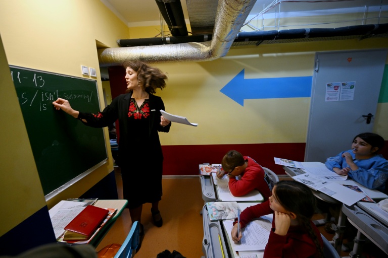 Des écoliers ont classe dans un abri installé au sous-sol de leur école primaire pendant une alerte aérienne en banlieue de Kiev, le 20 octobre 2026