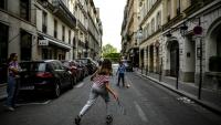 Des enfants jouent au tennis dans une rue de Paris le 21 avril 2020, en plein confinement lié au Covid-19 