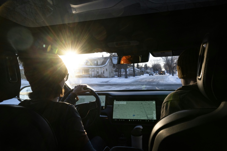 Des observateurs surveillant les agents de la police de l'immigratin (ICE) roulent dans un quartier de Minneapolis, dans le Minnesota, le 26 janvier 2026