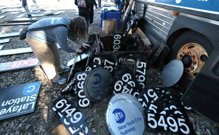 Une femme cherche parmi des panneaux du métro à l'occasion d'une vente annuelle organisée par la régie des transports de New York (MTA), le 9 octobre 2026.