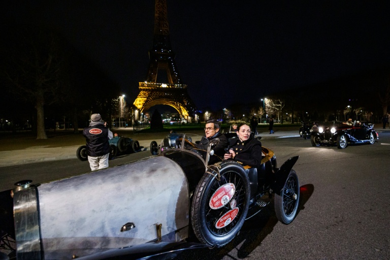 Une voiture de collection Bugatti sur le champ de Mars, devant la tour Eiffel, durant la parade nocturne pour les 50 ans de Rétromobile, le 26 janvier 2026, à Paris
