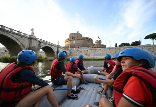Des personnes naviguent en canot pneumatique sur le Tibre, passant devant le château Saint-Ange, sur un tronçon du fleuve situé entièrement dans la zone urbaine du centre de Rome, le 14 août 2026