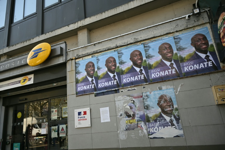 Des affiches électorales du candidat (sans étiquette) à la mairie de Sarcelles, Bassi Konaté, sur façade d'un bureau de poste à Sarcelles, le 20 mars 2026 dans le Val-d'Oise