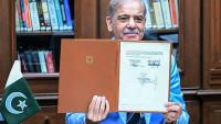 Le Premier ministre pakistanais Shehbaz Sharif montre le protocole d'accord signé par les présidents américain et iranien, après l'avoir lui-même signé en tant que médiateur, le 18 juin 2026 à Islamabad