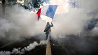 Un manifestant agite un drapeau français au milieu des gaz lacrymogènes lors d'une nouvelle manifestation contre la vie chère, le 31 octobre 2026 à Lyon