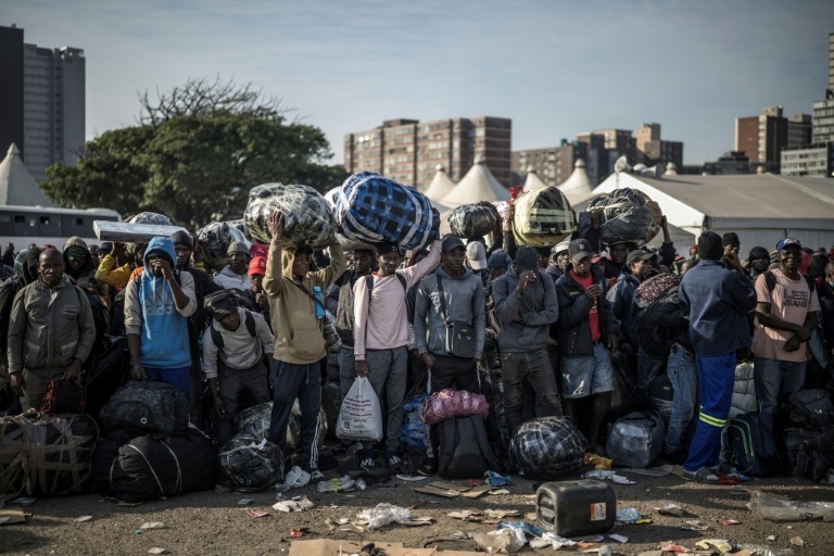 Des immigrés en situation irrégulière attendent d'être transférés en bus vers la frontière avec le Zimbabwe, le 29 juin 2026 à Durban, en Afrique du Sud
