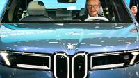Le chancelier allemand Friedrich Merz assis dans une BMW IX3 sur le stand du constructeur automobile lors de l'ouverture du Salon international de l'automobile IAA, le 9 septembre 2025 à Munich, dans le sud de l'Allemagne