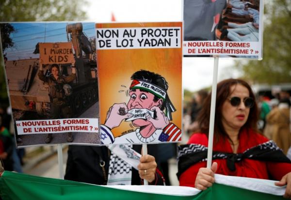 (ARCHIVES) Une personne brandit une pancarte sur laquelle on peut lire « Non au projet de loi Yadan » alors que des manifestants participent à un rassemblement contre ce projet de loi, qui vise à lutter contre les nouvelles formes d'antisémitisme, à Paris, le 12 avril 2026.