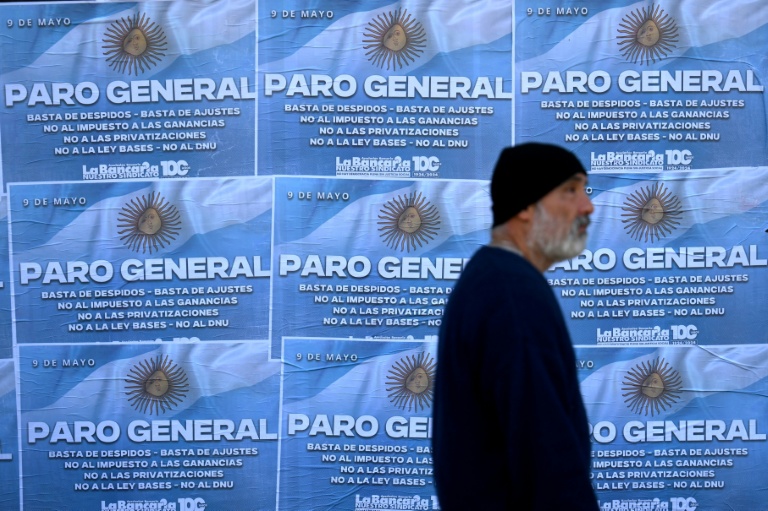 Un homme passe devant des affiches appelant à la grève générale le 9 mai 2024 à Buenos Aires, la deuxième depuis le début du mandat du président argentin Javier Milei
