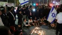 De jeunes Israéliens allument des bougies à la mémoire des victimes sur le site de la fusillade de la nuit dernière à Jérusalem-Est, le 28 janvier 2023