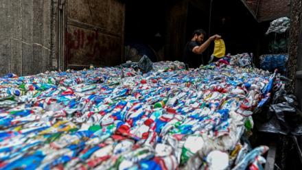 Un ouvrier égyptien conditionne du plastique destiné à être recyclé dans une usine de la "ville des déchets, dans le quartier de Manshiyet Nasser, au Caire le 6 juillet 2026