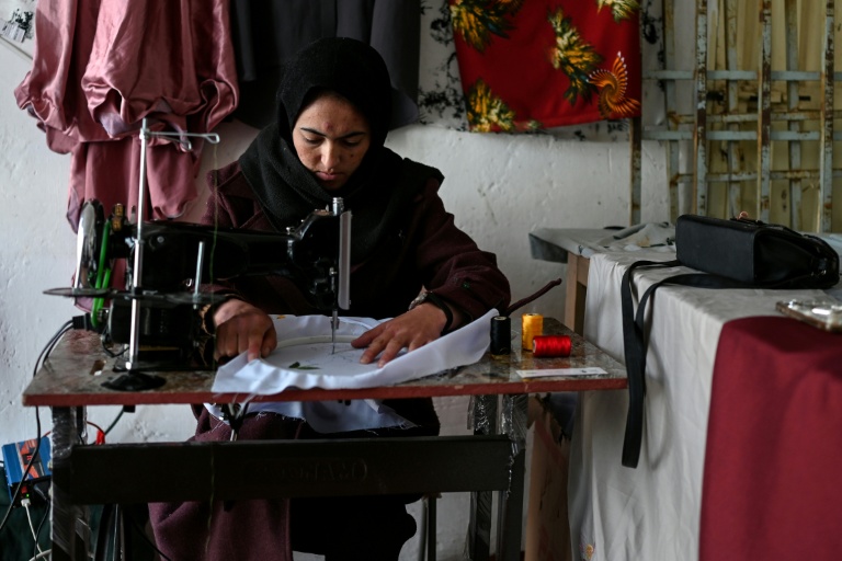 La couturière Rahima Alavi brode à la machine à coudre une écharpe dans sa boutique à Bamiyan, le 26 janvier 2026 en Afghanistan