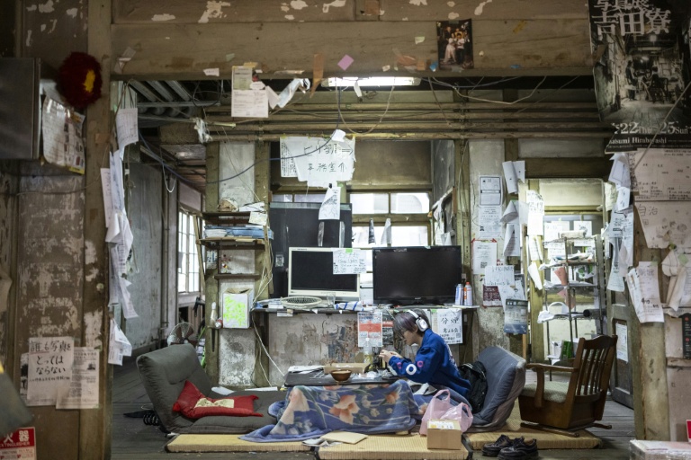 Un résident du Foyer Yoshida de l'Université de Kyoto examine un générateur électrique dans le hall d'entrée, le 3 févroer 2026 au Japon