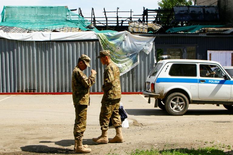 Des soldats devant le bâtiment calciné d'un restaurant après une explosion de gaz survenue en février, le 27 mai 2026 à Chtchoutchinsk, au Kazakhstan