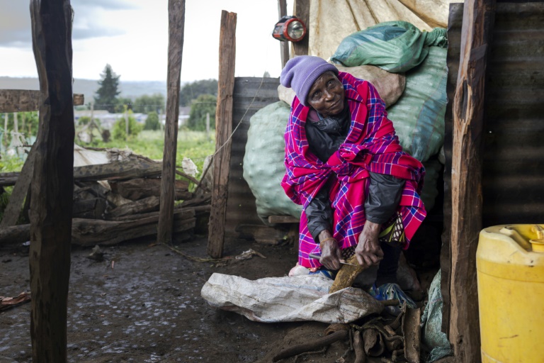 Janet Sumpet Ngusilo, grand-mère du militant des droits de l'homme de la communauté Ogiek Fred Ngusilo, prépare un repas à l'extérieur de la chambre qu'elle loue à Oloikirikirai où elle vit depuis que sa communauté a été expulsée de la forêt de Mau, dans le comté de Narok, le 16 août 2025 au Kenya
