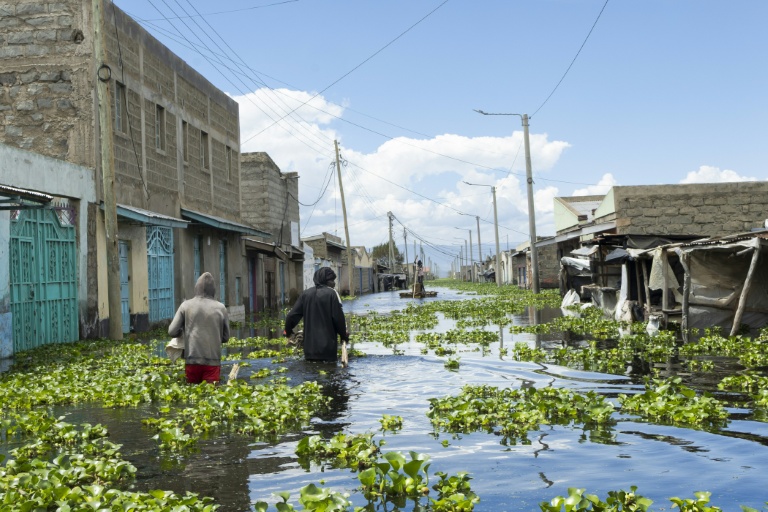 Des habitants traversent leur quartier des bords du lac Naivasha, dans le centre du Kenya, inondé par la montée des eaux, le 17 novembre 2025