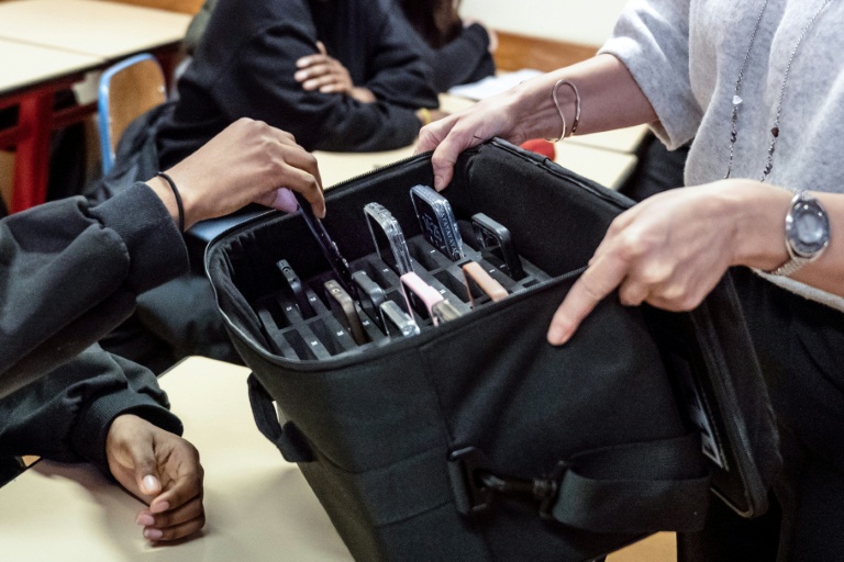 Une enseignante récupère les téléphones portables des élèves, mis de côté pendant les cours au lycée professionnel Jean Mermoz de Montsoult, le 14 janvier 2026 dans le Val-d'Oise
