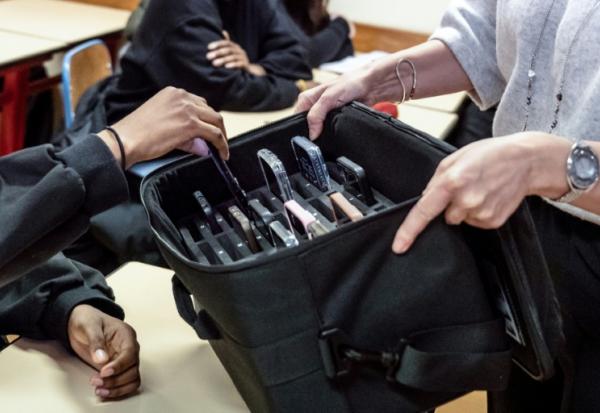 Une enseignante récupère les téléphones portables des élèves, mis de côté pendant les cours au lycée professionnel Jean Mermoz de Montsoult, le 14 janvier 2026 dans le Val-d'Oise