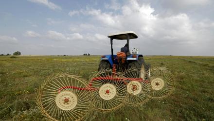 Un agriculteur utilise une machine de ramassage du foin dans un champ de la région de Zehiliga, au Maroc, le 28 avril 2026