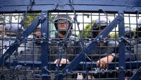 Des policiers montent la garde lors d'une manifestation de partisans de l'ancien Premier ministre népalais KP Sharma Oli protestant contre son arrestation, le 29 mars 2026 à Katmandou, au Népal