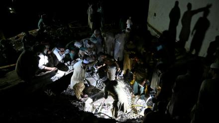 Sans électricité, des villageois et secouristes fouillent les décombres de maisons dévastées par la mousson, à la recherche de survivants ou de dépouilles de victimes, dans le village de Dolari, dans le nord du Pakistan, le 18 août 2025
