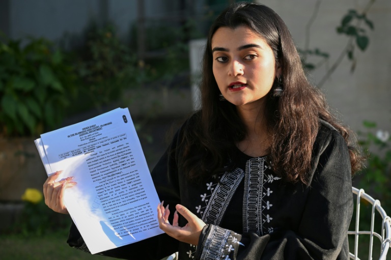 Hania Imran, militante pour le climat, tient une copie de la plainte qu'elle a déposée contre l'État en décembre 2024 pour le 