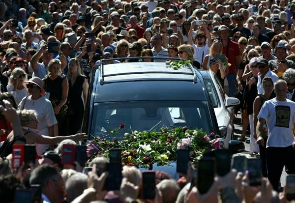 Des fans endeuillés se pressent le long des rues pour rendre hommage à la chanteuse Bonnie Tyler, dont le corbillard, transportant son cercueil, traverse sa ville natale de Mumbles, dans le sud-ouest du Pays de Galles, le 15 août 2026.