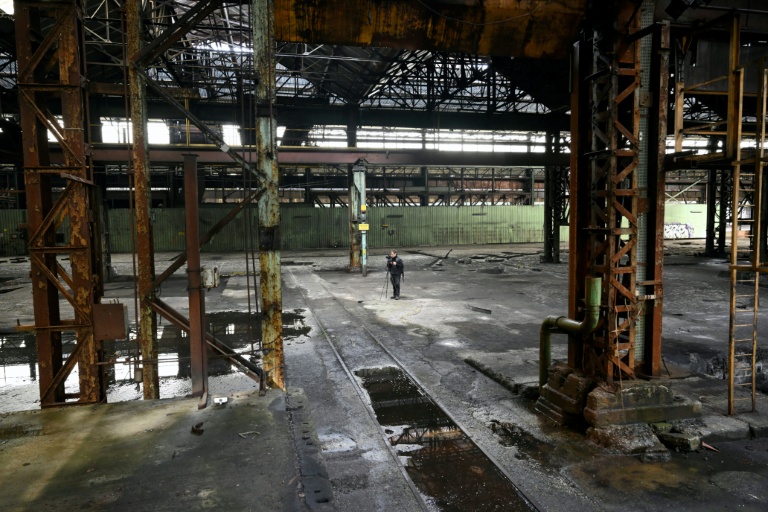 Un explorateur urbain (urbex) prend des photos dans une aciérie à l'abanon à Charleroi, dans le sud de la Belgique, le 9 février 2026