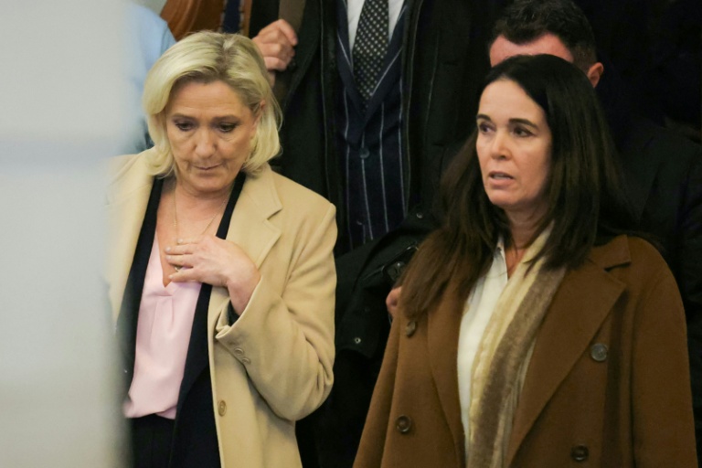 La présidente du Rassemblement national, Marine Le Pen (à gauche), quitte la salle d'audience au premier jour de son procès en appel
