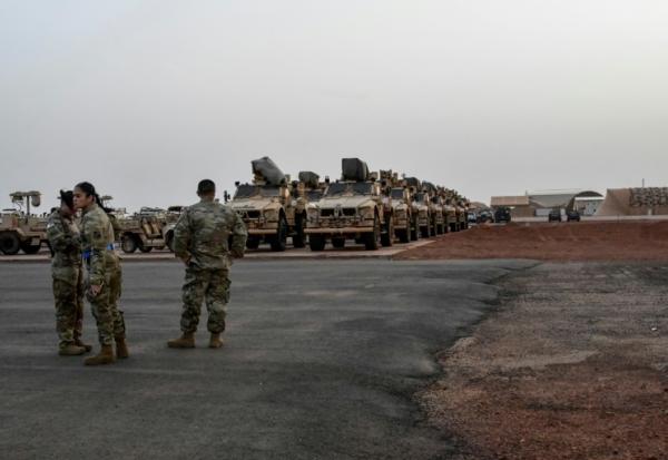 Des soldats américains devant des véhicules militaires prêts à embarquer à bord d'un avion cargo à Niamey, le 7 juin 2024, lors de la cérémonie du premier départ des troupes américaines du Niger