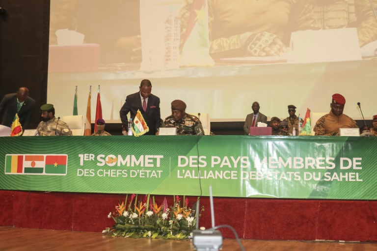 Le chef de la junte du Niger, le général Abdourahamane Tiani (C), le général malien Assimi Goïta (G) et le capitaine burkinabè Ibrahim Traoré (D) signent la charte portant création de la Confédération des États du Sahel (AES) lors de leur premier sommet à Niamey le 6 juillet 2024 au Niger
