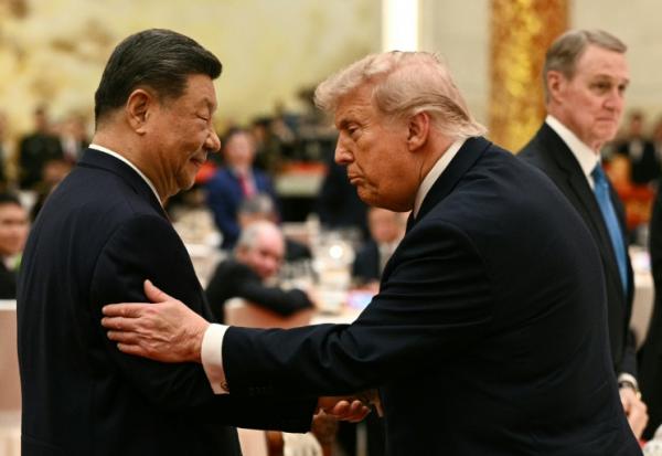 Le président chinois Xi Jinping (g) et le président américain Donald Trump lors d'un banquet d'État au Palais de l'Assemblée du Peuple à Pékin, le 14 mai 2026