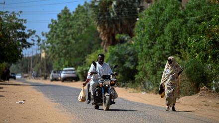 Un bénévole soudanais chargé de livrer des médicaments à domicile roule en moto à Khartoum, le 18 avril 2026