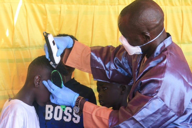 Des garçons soudanais originaires d'El-Facher, dans l'ouest du Soudan, se font couper les cheveux dans un camp pour personnes déplacées dans la ville d'Al-Dabbah, dans le nord du Soudan, le 22 novembre 2025