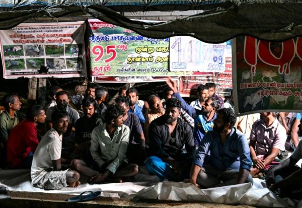 Des éleveurs tamouls installés sous une bâche pour protester contre une spoliation foncière, le 30 septembre 2026 à Batticaloa, dans l'est du Sri Lanka