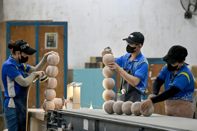 Des ouvriers de l’entreprise de mobilier Jonathan Charles poncent des pièces le 4 novembre 2025 à Ho Chi Minh-Ville