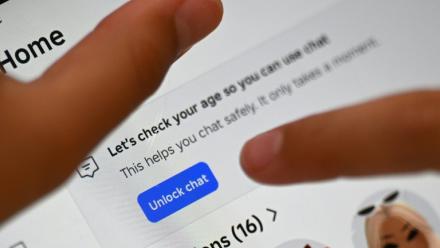 Une enfant tente de débloquer l'accès à un réseau social après avoir reçu un message de vérification d'âge, à Sydney, le 10 décembre 2025