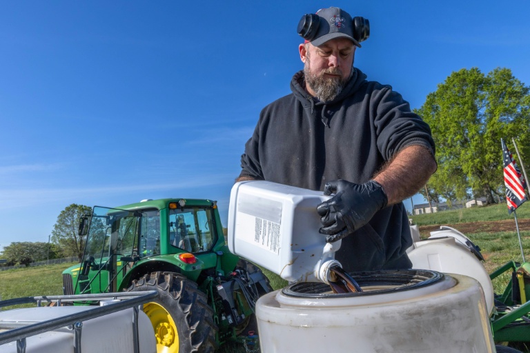 L'agriculteur Russell Hedrick prépare un mélange de minéraux, de produits biologiques et d'engrais pour le pulvériser sur ses champs lors des semis à Hickory, en Caroline du Nord, le 10 avril 2026