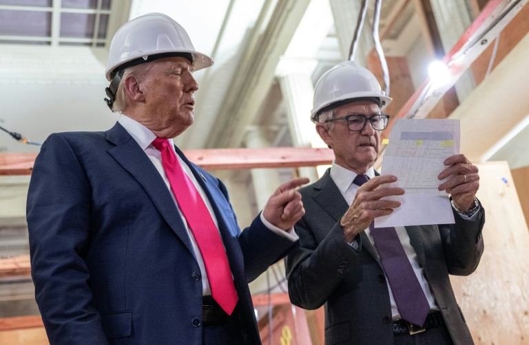Le président américain Donald Trump montre une feuille détaillant des coûts à Jerome Powell (r), président de la Réserve fédérale, lors d'une visite à la Réserve fédérale à Washington, le 24 juillet 2025